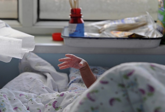 Một em bé đang giơ cánh tay non nớt tại bệnh viện phụ sản ở Chiết Giang, Trung Quốc.